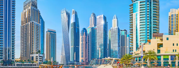 DUBAI, UAE - MARCH 2, 2020: Dubai Marina cityscape with a view on canal, harbor of Bristol Charter with moored wooden dhow boat and motor boats, on March 2 in Dubai
